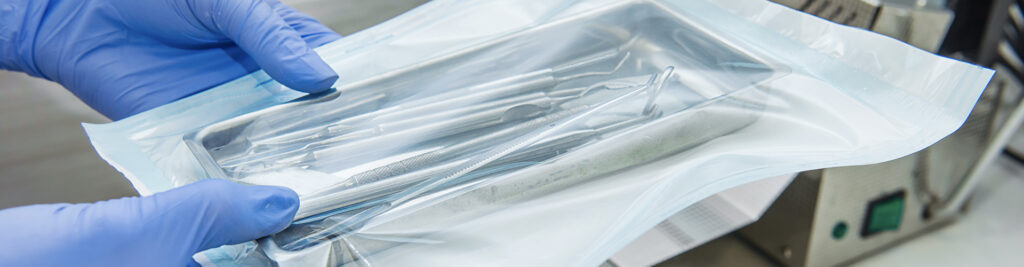medical employee holding a sterilized bag of dental tools